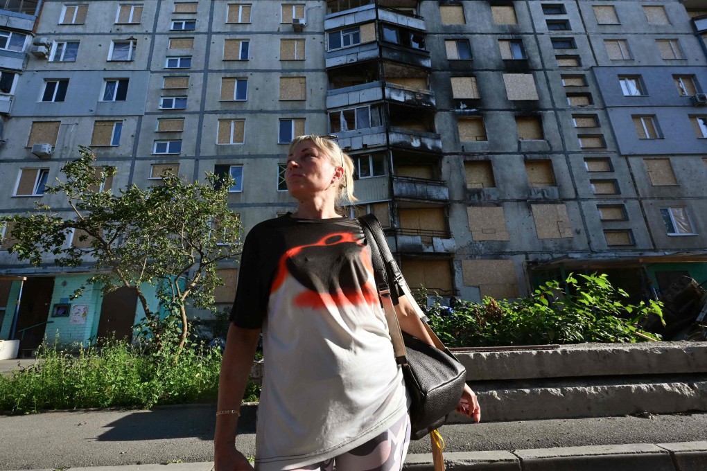 Tetiana Bezatosna, 44, stands in front of a heavily damaged by Russian strikes residential building where she lived, in Kharkiv’s Saltivka district. Photo: AFP