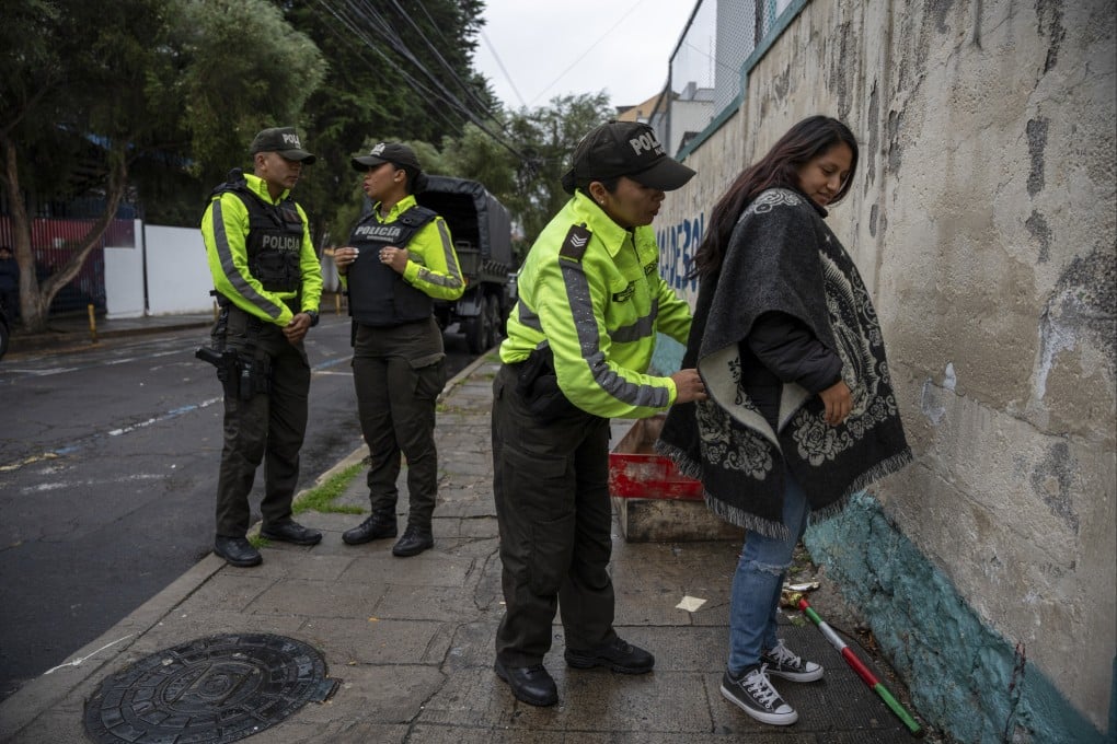 Police frisk a voter during a snap presidential election in Quito, Ecuador, on Sunday. Photo: AP