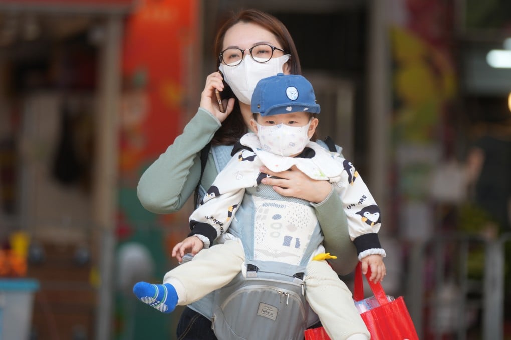 A woman carries a child in Hong Kong’s To Kwa Wan district on March 7. For many parents, it is no longer adequate to ensure their children win at the starting line but, more importantly, stay competitive until the finishing line. Photo: Sam Tsang