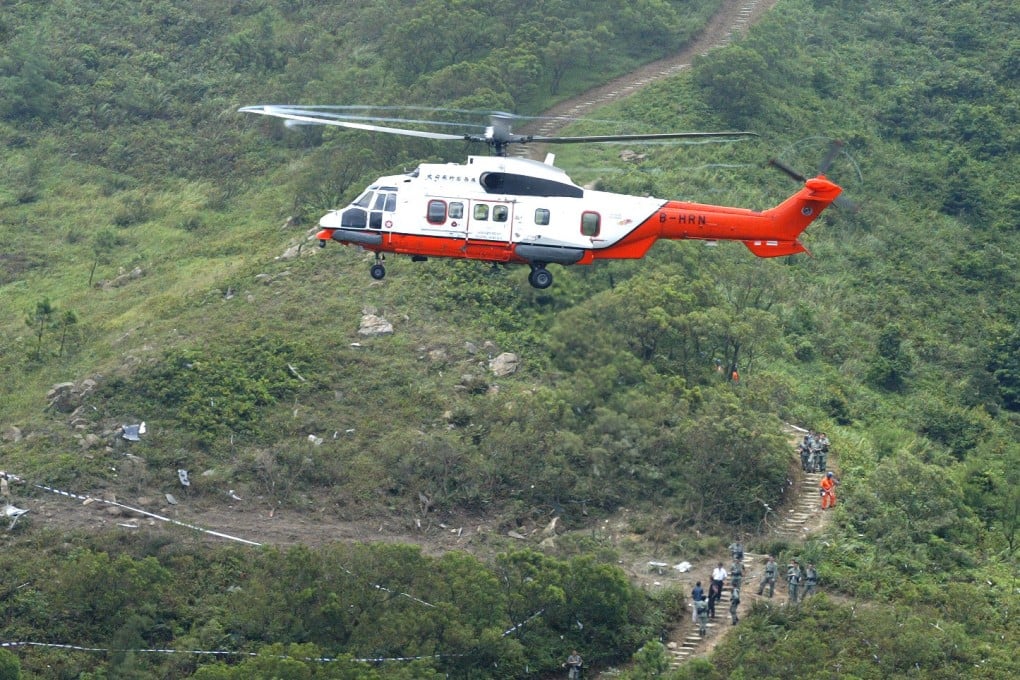 A Government Flying Service helicopter hovers over the site on Lantau Island, Hong Kong, where another GFS helicopter crashed in 2003, killing both crew. Photo: SCMP