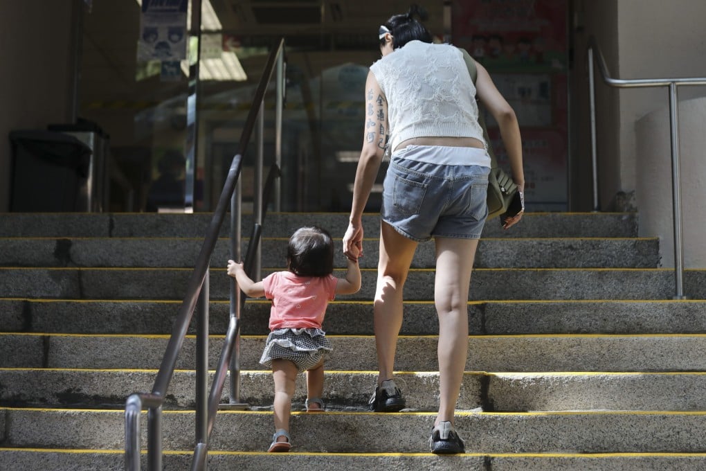 A woman with a toddler enters Tsan Yuk Hospital in Sai Ying Pun on August 15. Hong Kong’s fertility rate has hit a record low, sparking calls for reforms to provide more support to young families and make the city more family-friendly. Photo: Xiaomei Chen