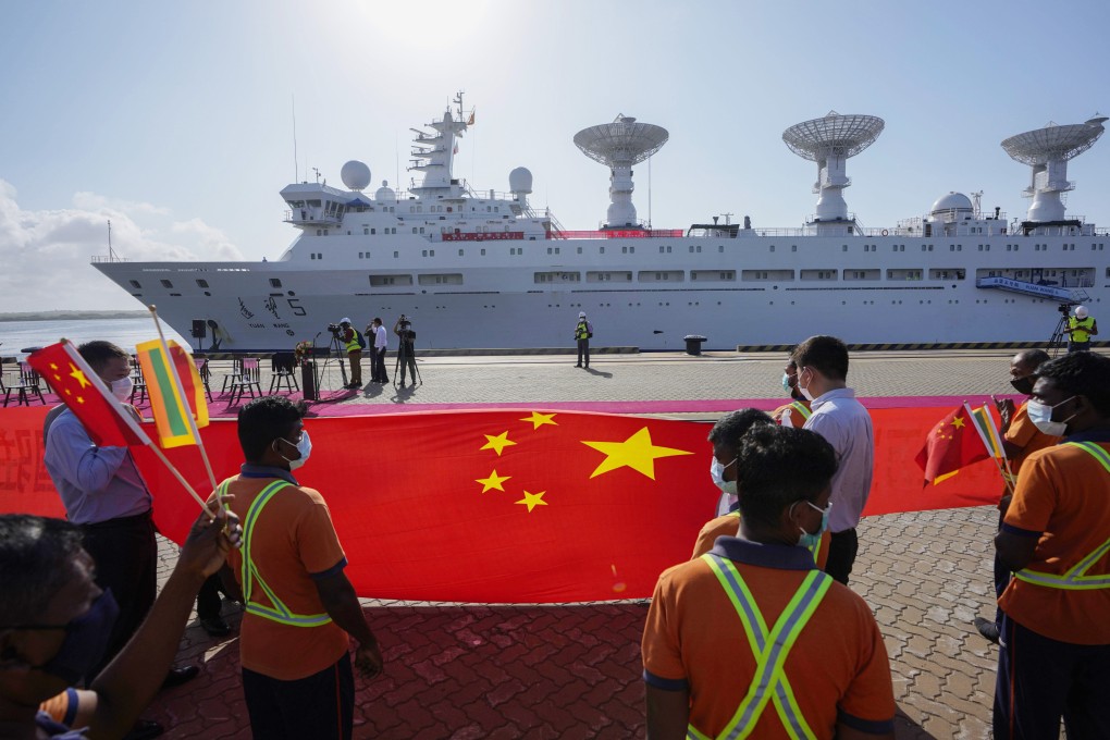 Sri Lankan port workers hold a Chinese national flag to welcome Chinese research ship Yuan Wang 5 at the Hambantota port in Sri Lanka on August 16, 2022. Photo: AP