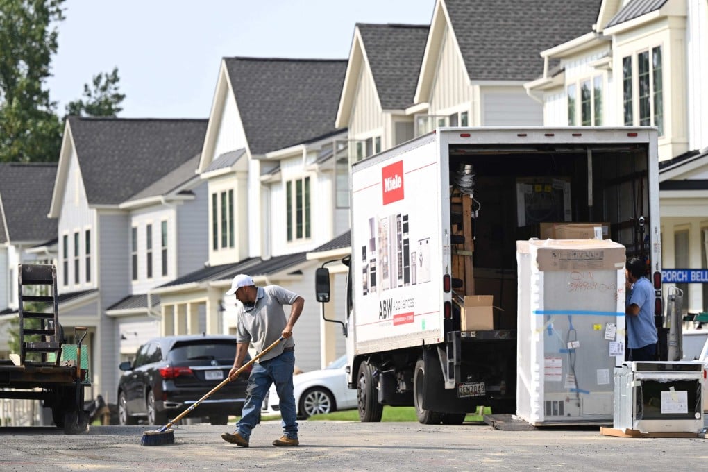 A maintenance worker sweeps the street in front of a row of new homes in Fairfax, Virginia, on August 22. Sales of homes in the United States fell in July as elevated mortgage rates and limited housing supply held buyers back. Photo: AFP