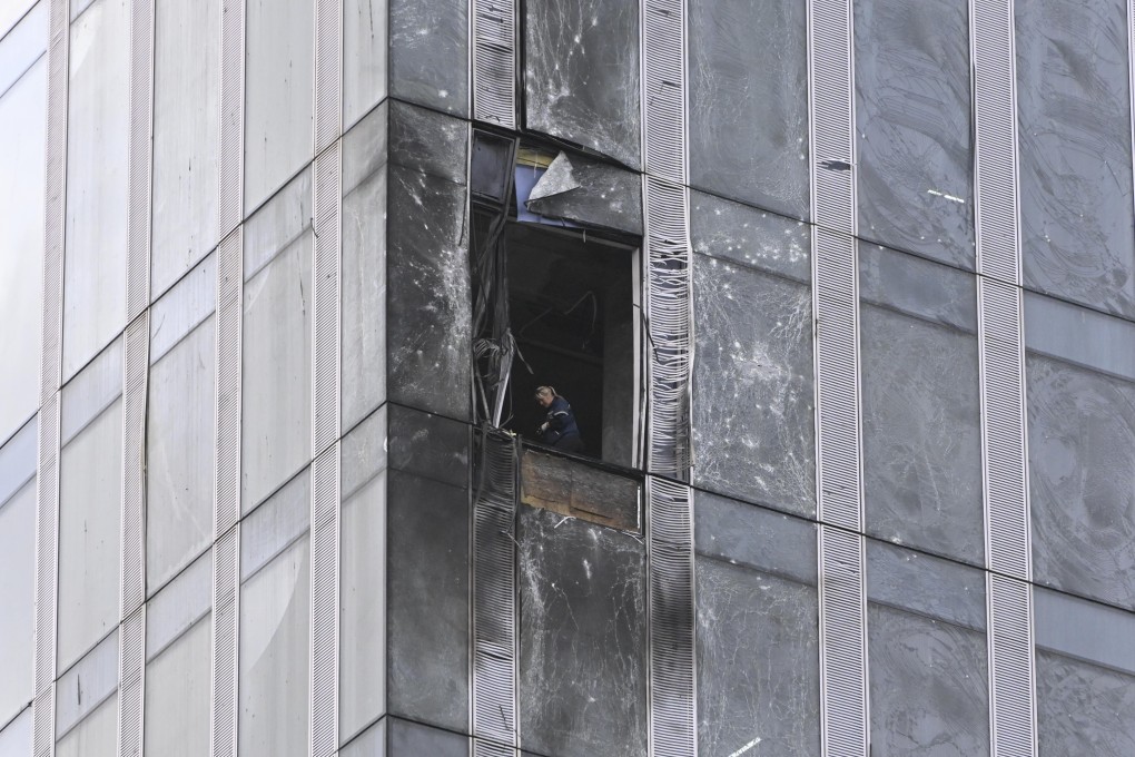 An investigator examines a damaged skyscraper in Moscow City business district after a reported drone attack. Photo: AP
