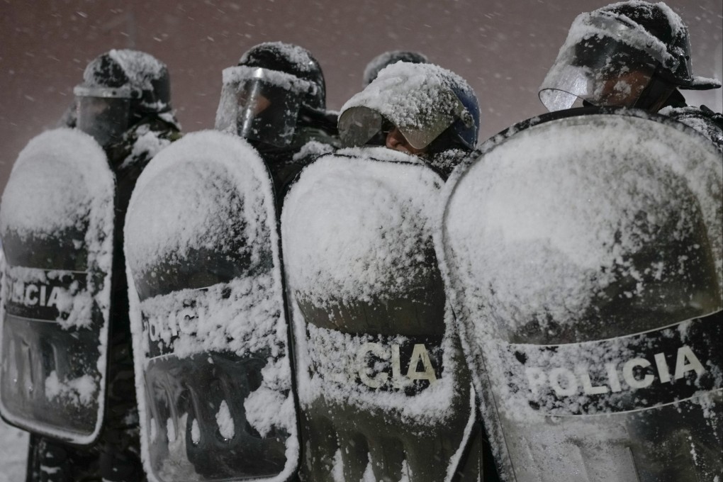 Police guard a supermarket after reports that looters tried to break into the store in Bariloche, Argentina. Photo: AP