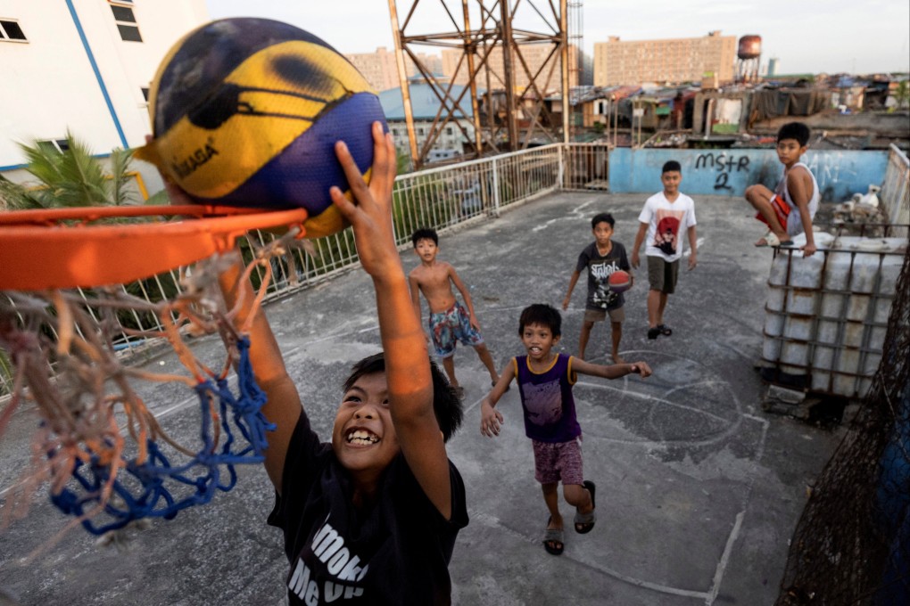 Children play basketball on the rooftop of tenement housing in Tondo, Manila. Photo: Reuters