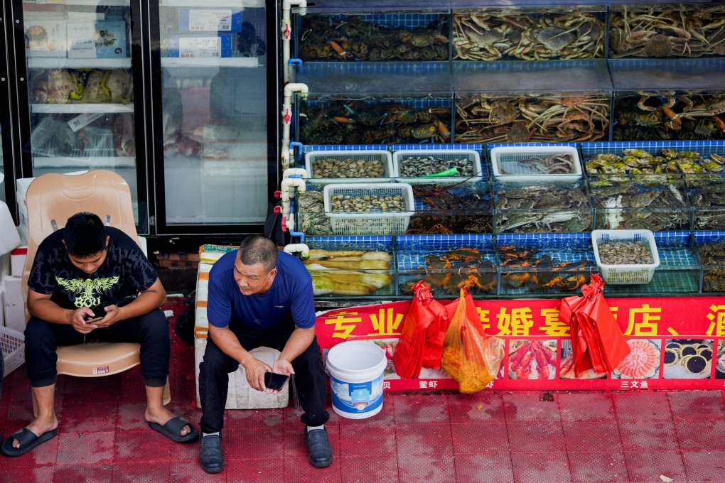 Vendors wait for customers at a seafood market in Shanghai on Friday. China has abruptly halted all seafood imports from Japan after it began releasing treated Fukushima waste water. Photo: Reuters