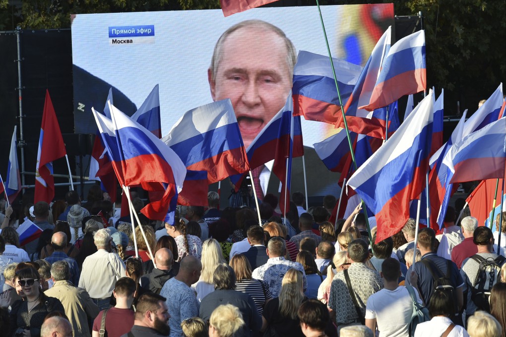 People watch as Russian President Vladimir Putin delivers a speech. File photo: AP