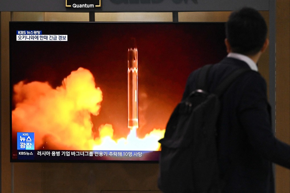 A man walks past a television screen showing a news broadcast with file footage of a North Korean missile test, at a train station in Seoul, South Korea on Thursday. Photo: AFP