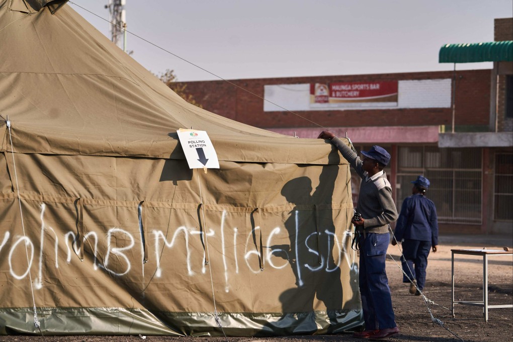 A Zimbabwean police officer monitors a polling station during Zimbabwe’s presidential and legislative elections in Bulawayo on Wednesday. Photo: AFP