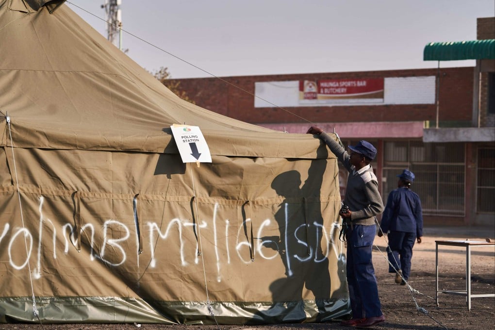A Zimbabwean police officer monitors a polling station during Zimbabwe’s presidential and legislative elections in Bulawayo on Wednesday. Photo: AFP