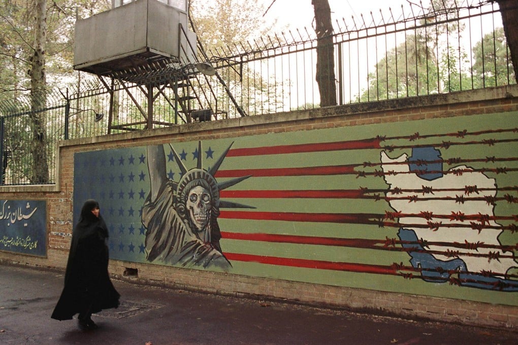 An Iranian woman walks past an anti-US mural outside the former US embassy in Tehran in 1999. Photo: AFP