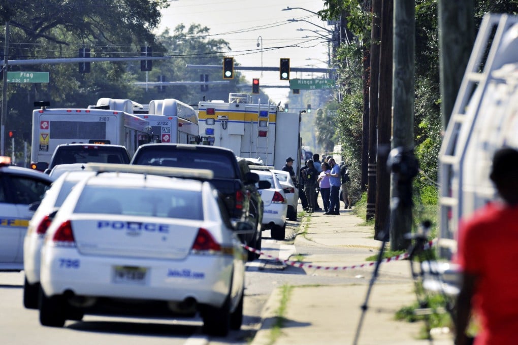 Emergency personnel surround a store after a white man armed with a high-powered rifle and a handgun killed three black people before shooting himself in Jacksonville, Florida. Photo: Reuters