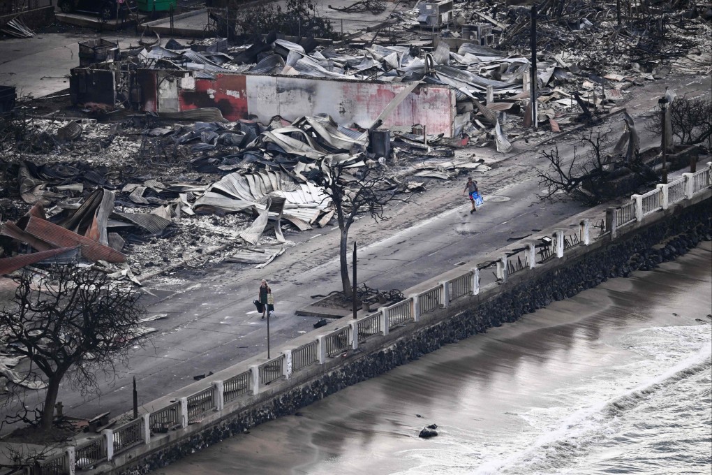People walk down a road past buildings burned to the ground in Lahaina, in the aftermath of wildfires in western Maui, Hawaii, on August 10. Photo: AFP