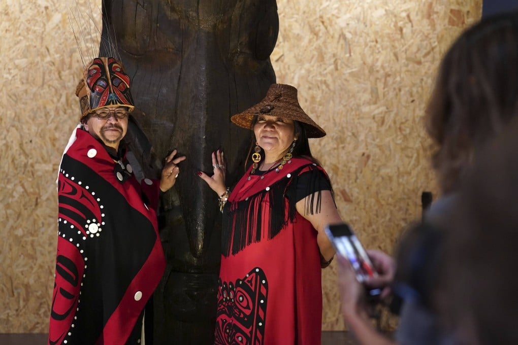 Earl Stephens, who has the Nisga’a cultural name Chief Ni’is Joohl, left, and Pamela Brown from the Nisga’a nation pose beside the totem pole at the National Museum of Scotland on Monday. Photo: AP