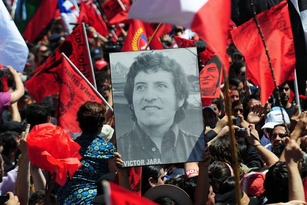 People hold a portrait of Chilean singer Victor Jara in Santiago, Chile in 2009. Photo: AFP