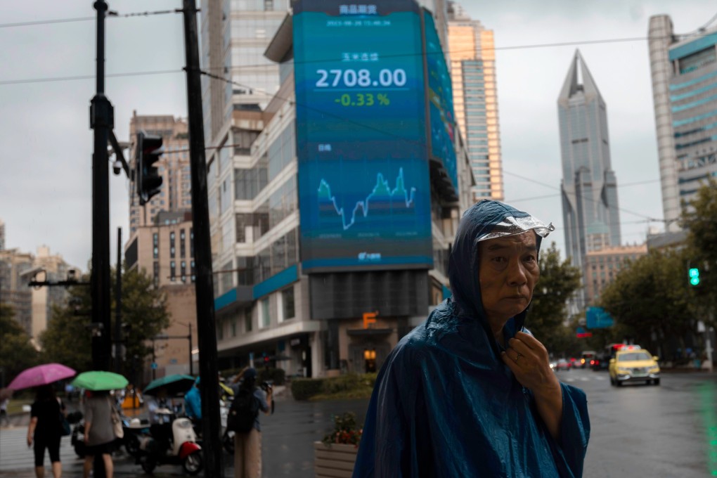A man walks on the street, in front of the large screen displaying the latest stock exchange data, in Shanghai on August 28. Photo: EPA-EFE