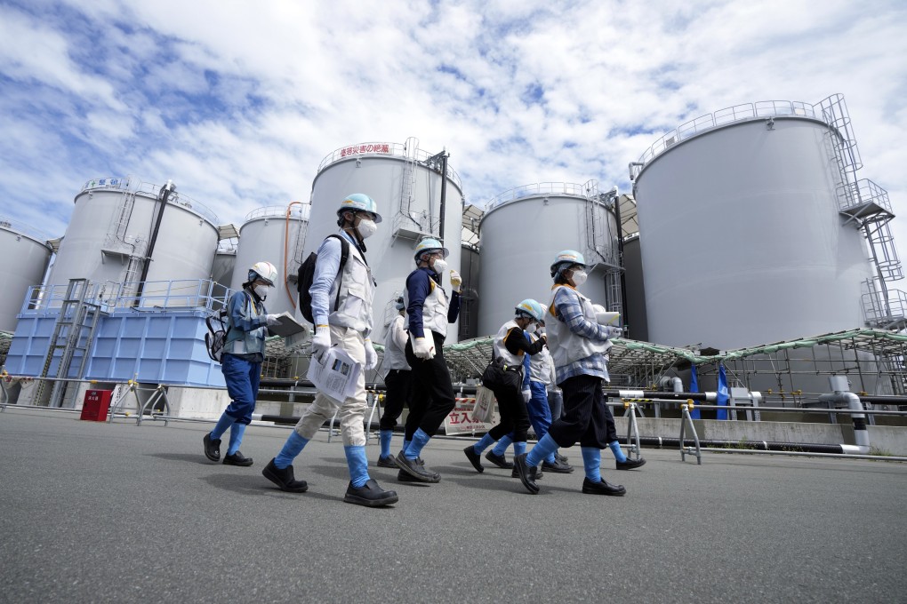 Journalists pass tanks containing treated radioactive wastewater at the Fukushima discharge facility in Japan. Photo: EPA