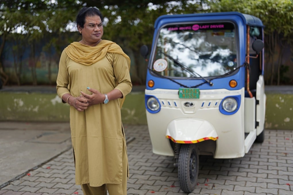 Preethi, a 38-year-old transgender woman, stands next to her electric auto rickshaw in Bengalore. Photo: AP