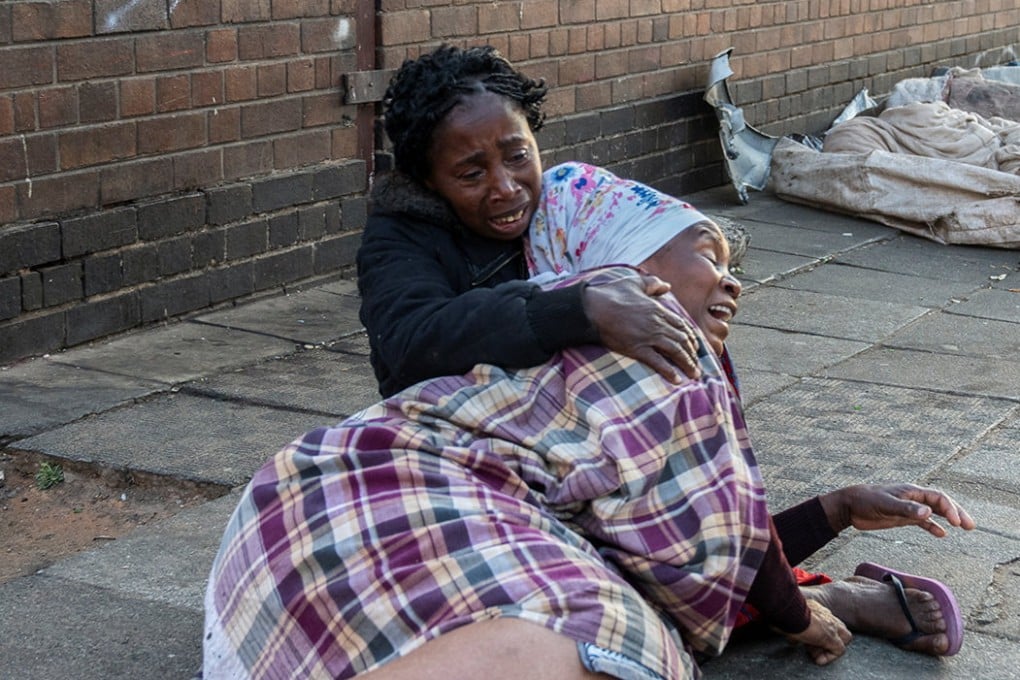 Women react after the deadly blaze in Johannesburg, South Africa. Photo: Reuters