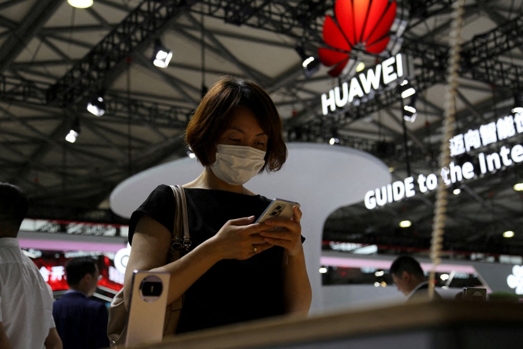 A visitor checks a mobile phone near the Huawei logo during the Mobile World Congress in Shanghai, China June 28, 2023. Photo: Reuters