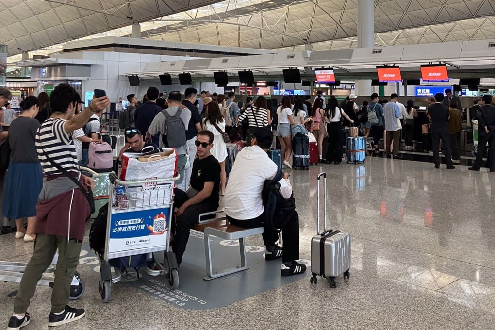 Travellers queue as they wait for news on their flights. Photo: Ambrose Li