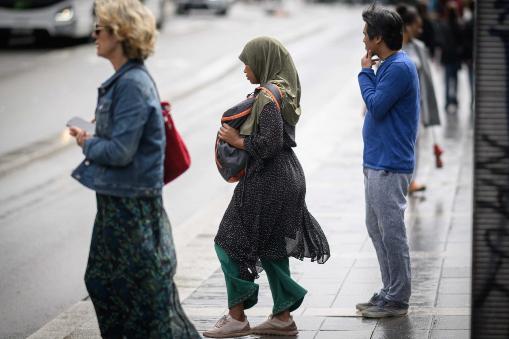 A young woman wears an abaya as she stands on a street in Nantes, France. Photo: AFP