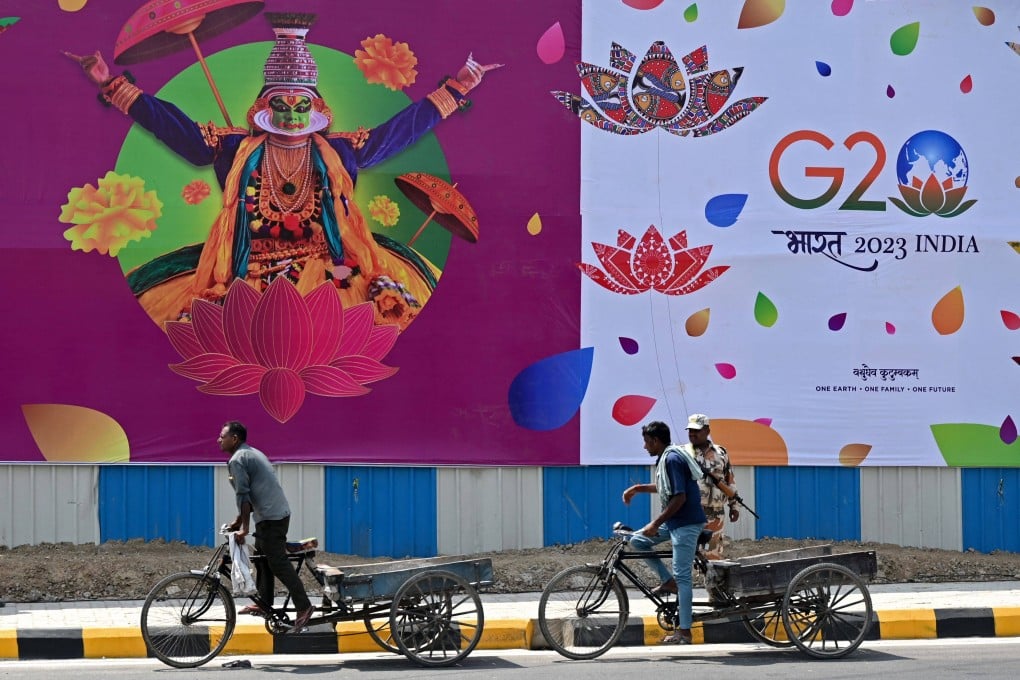Labourers pass a G20 India summit hoarding in New Delhi. India, which holds the rotating presidency, will have a tough job of reconciling positions to achieve concrete outcomes. Photo: AFP