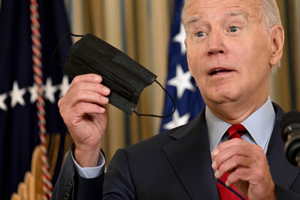 US President Joe Biden holds up a face mask while speaking at the White House on Wednesday. Photo: AFP