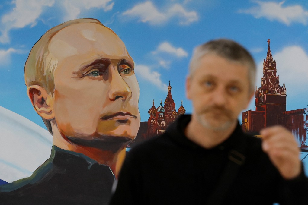 A man walks near a mural depicting President Vladimir Putin at a polling station during local elections in Donetsk. Photo: Reuters