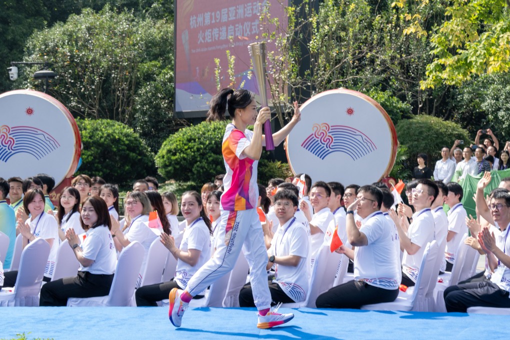 Torch bearer Luo Xuejuan, a former Olympic swimming champion and world record holder, kicked off the Hangzhou Asian Games torch relay in her home city. Photo: Xinhua