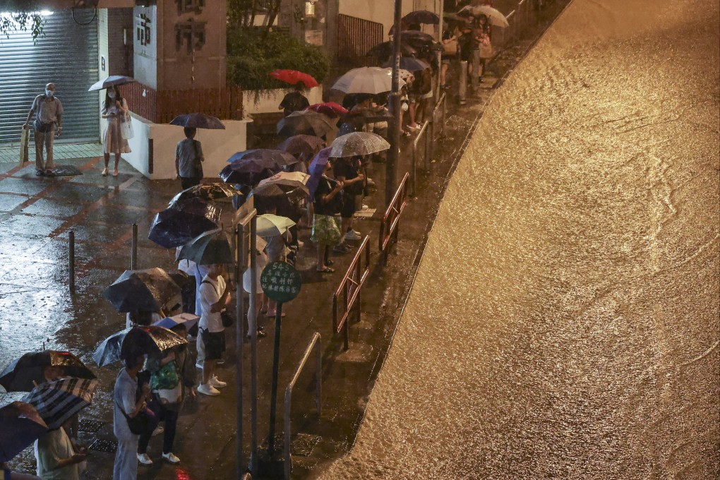 People queue at a bus stop as a road in Choi Hung turns into a torrent. Photo: Edmond So