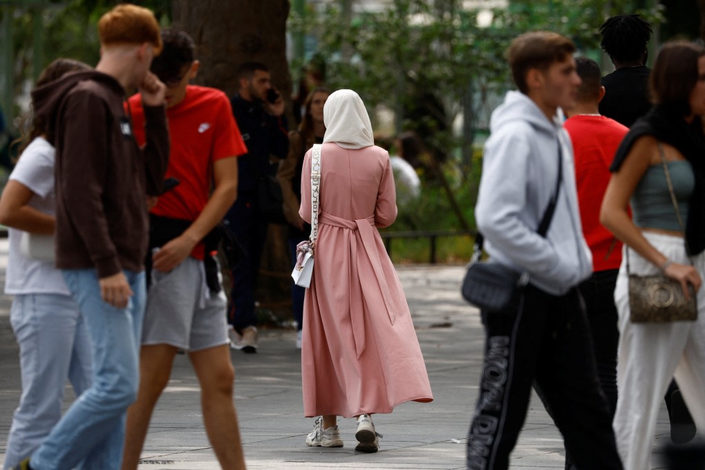 A woman in an abaya (centre) walks down a street in Nantes, France in August. Photo: Reuters