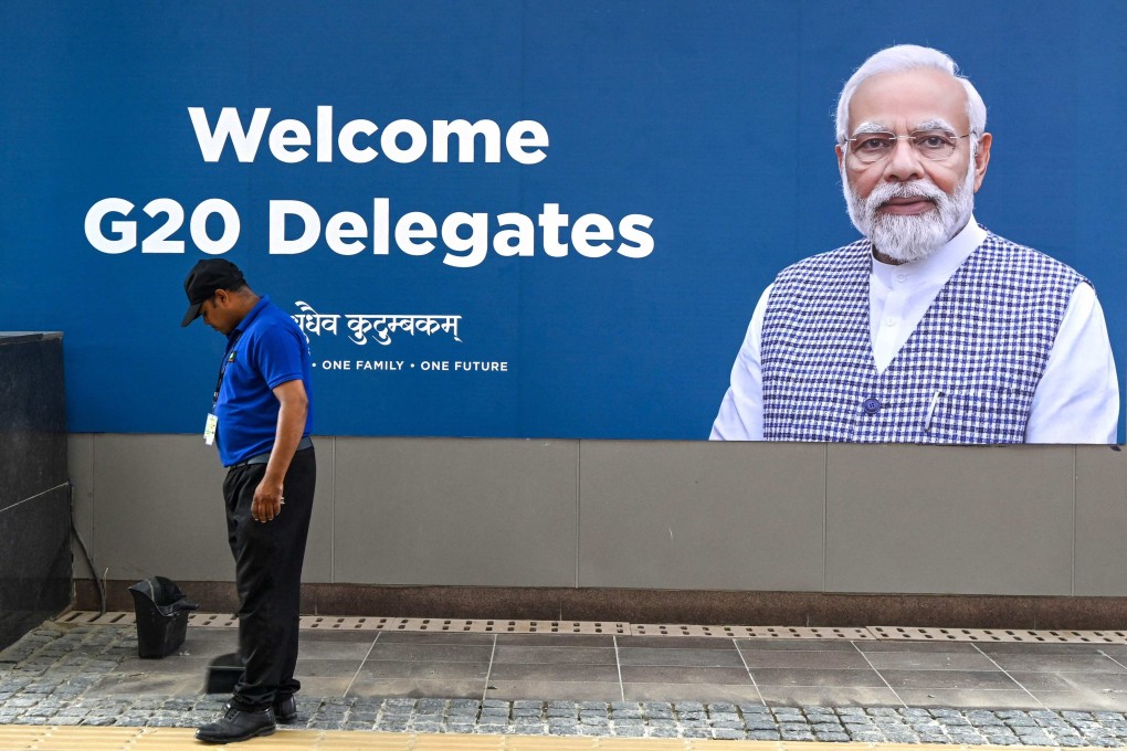 A worker in New Delhi cleans in front of a billboard with a portrait of Indian Prime Minister Narendra Modi at the G20 venue on Thursday. Photo: AFP