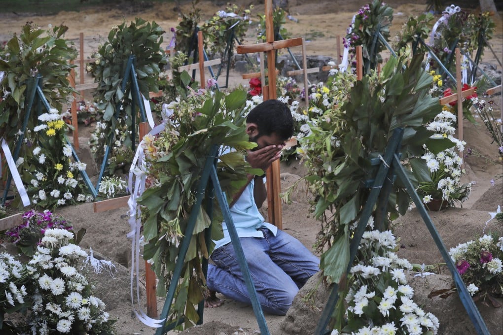 A relative of a victim of the 2019 Easter Sunday bomb blasts in Sri Lanka pays tribute at a burial site. File photo: AP