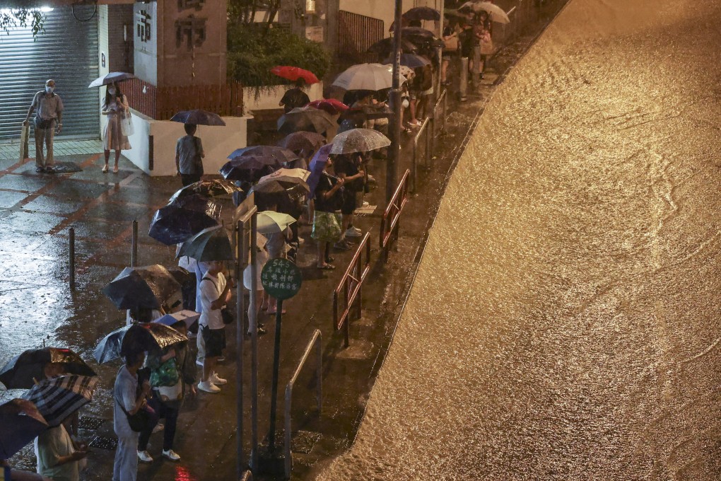 People queue at a bus stop as a road in Choi Hung, Hong Kong, turns into a torrent. Photo: Edmond So