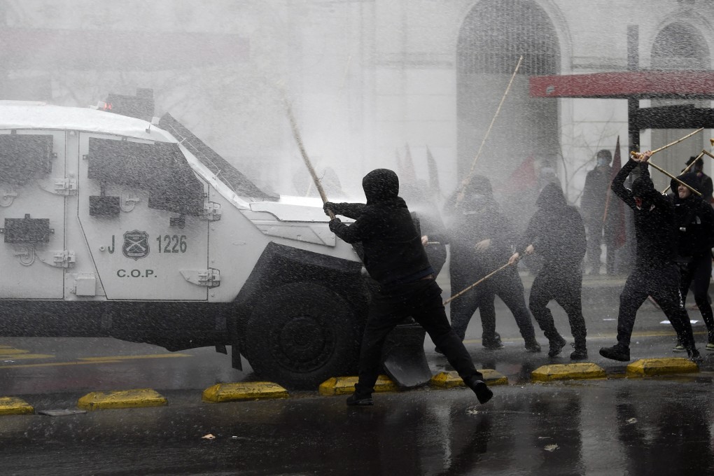 Protesters clash with riot police during a march to commemorate the victims of dictator Augusto Pinochet, in Santiago, Chile on Sunday. Photo: AFP