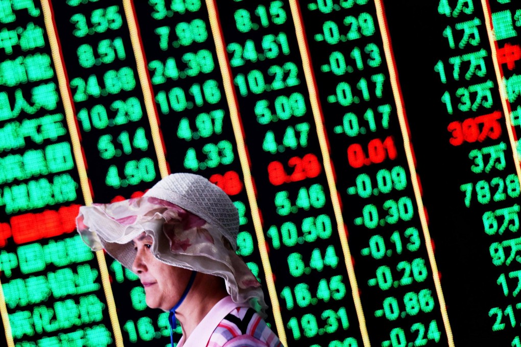 An investor walks past a screen showing stock market figures at a securities company in Hangzhou in eastern Zhejiang province. Photo: AFP