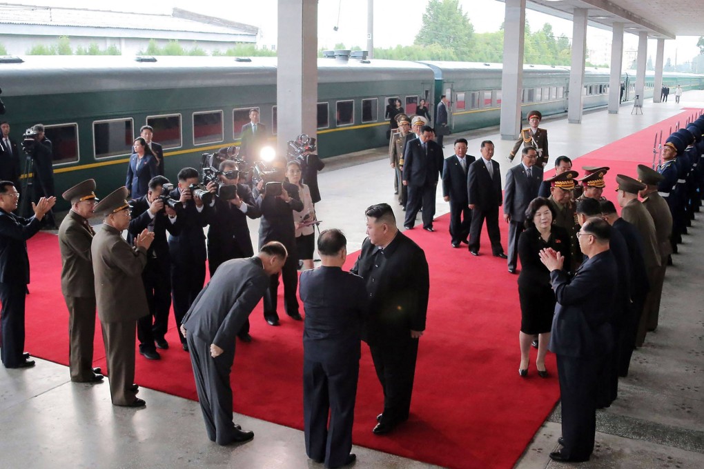 North Korean officials bow to Kim Jong-un before he departs by train on Sunday for his first trip outside his country since the onset of the Covid-19 pandemic. Photo: KCNA via KNS / AFP