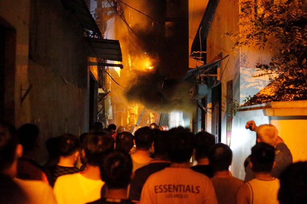 People watch a fire at an apartment building in Hanoi on Wednesday. Photo: AFP