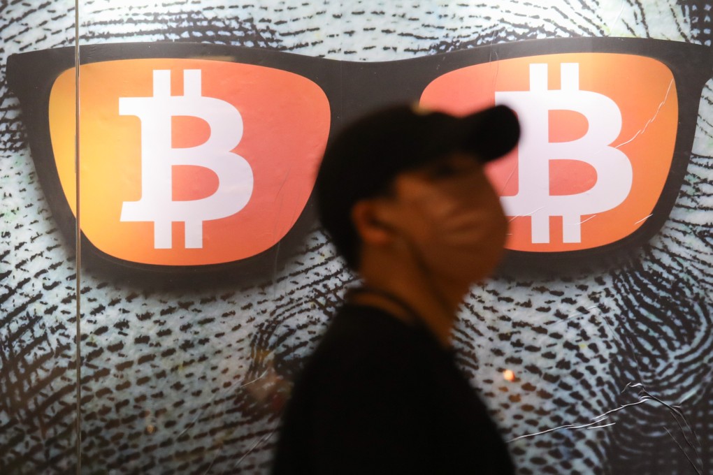 A pedestrian walks past a billboard featuring Bitcoin in Admiralty on September 1, 2022. Photo: SCMP / Yik Yeung-man