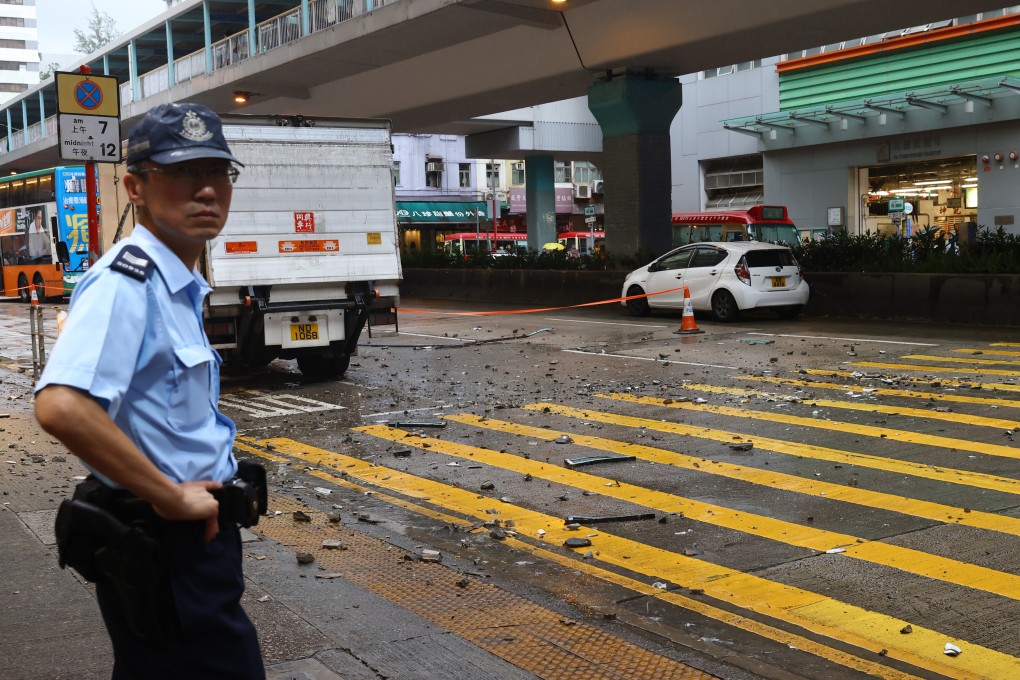 An officer surveys the site where pieces of concrete fell from the 57-year-old residential Po On Building in Mong Kok, damaging a truck and injuring a pedestrian. Calls for inspections and repairs have intensified amid a rash of similar incidents. Photo: Dickson Lee