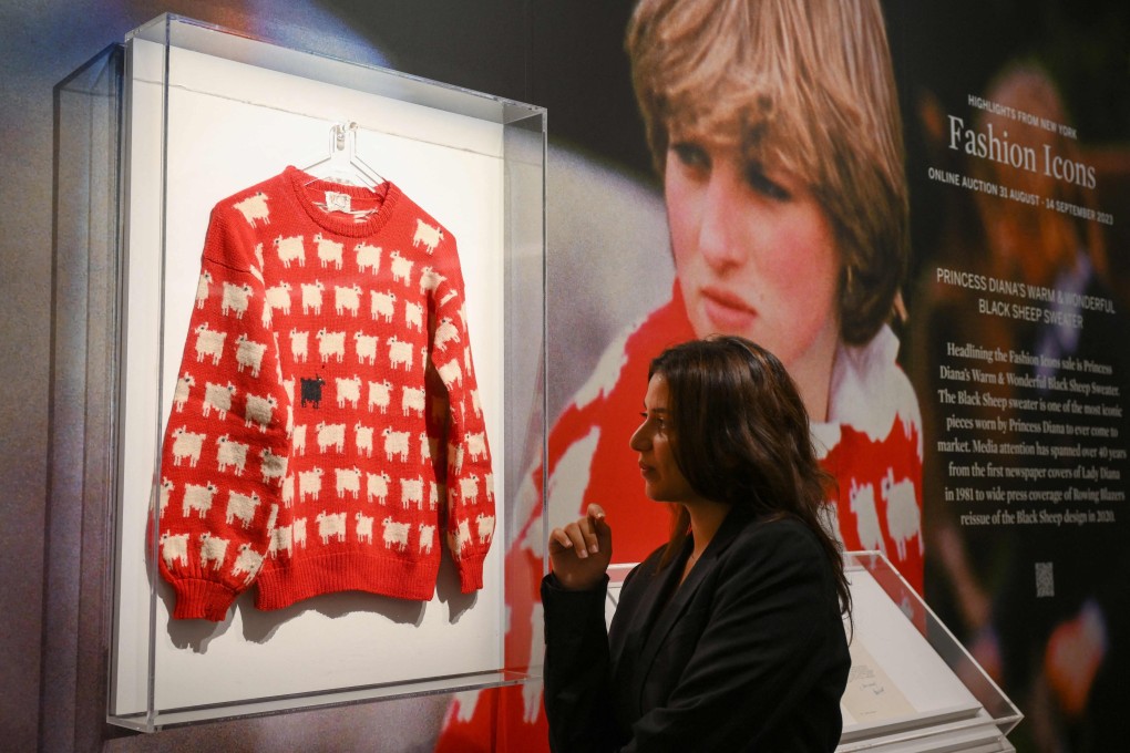 A staff member poses with Princess Diana’s “Black Sheep” jumper at Sotheby’s auction house in London in July. Photo: AFP