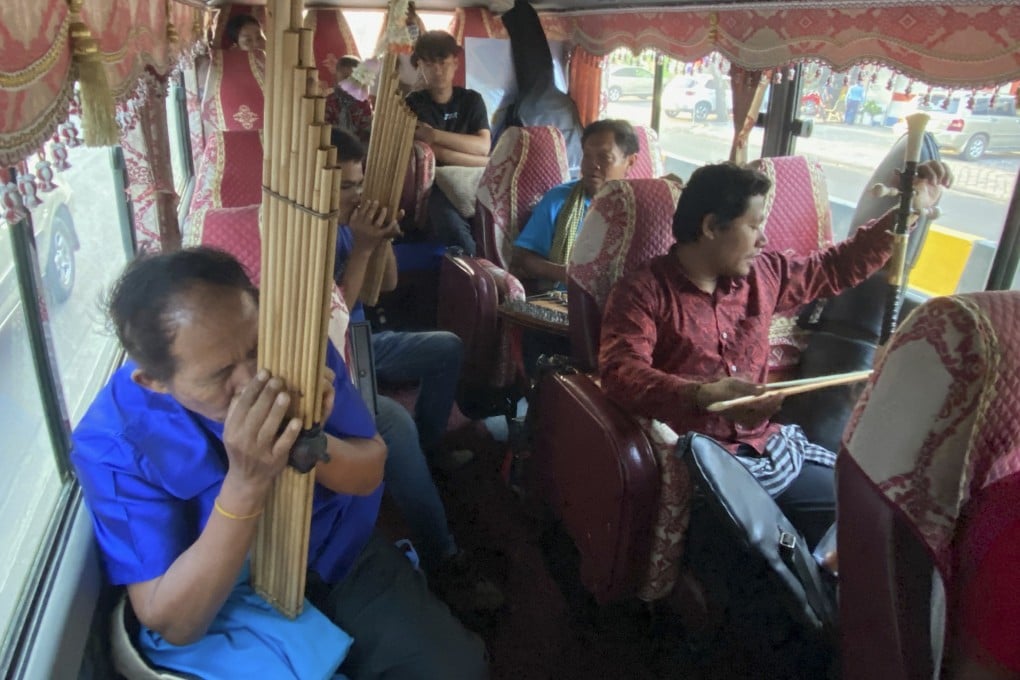 On board the Khmer Magic Music Bus with their traditional Cambodian musical instruments is Mon Hai (bottom left), playing the khen mouth organ; Nou Samnang behind him, also on the khen; Thouch Savang, on the dulcimer-like kim, and Chek “Sinath” Samnang, on the tro Khmer, a vertical fiddle. Photo: Patrick Scott