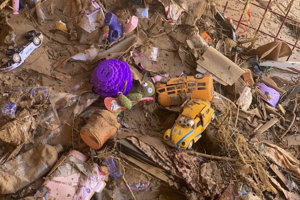 Toys scattered outside a damaged house in Derna, Libya. Search teams are combing streets, wrecked buildings, and even the sea to look for bodies. Photo: AP