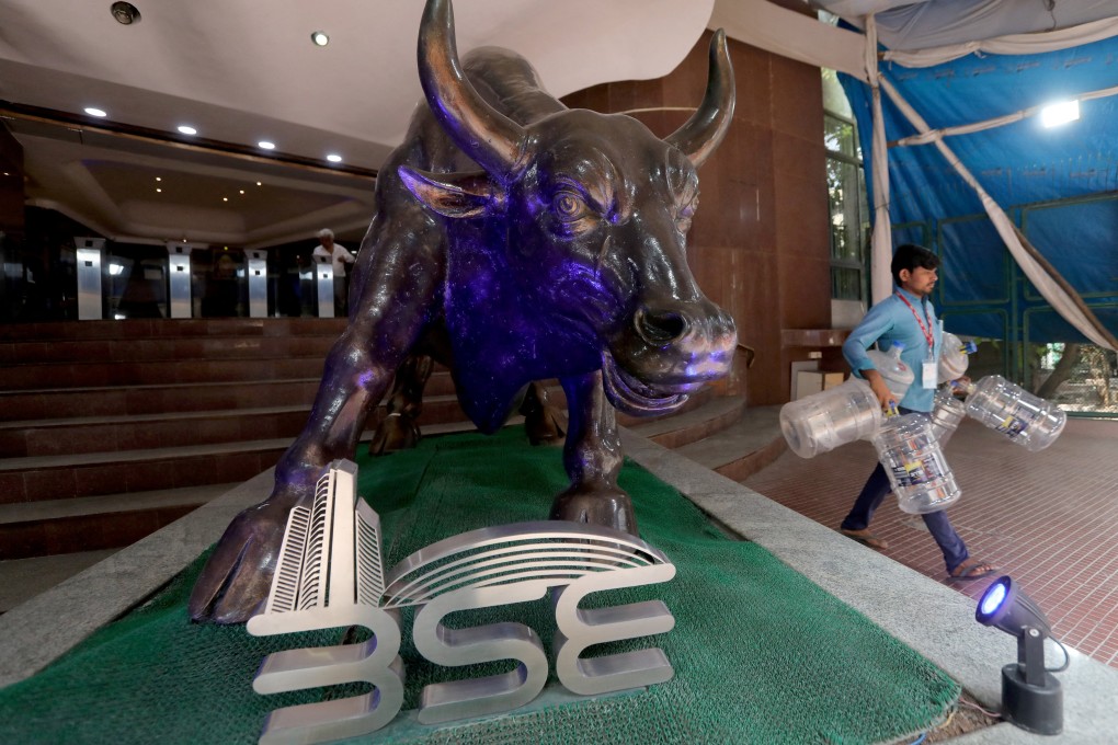 A man carries empty water bottles past a bronze bull statue inside the premises of the Bombay Stock Exchange in Mumbai on February 1, 2023. Photo: Reuters