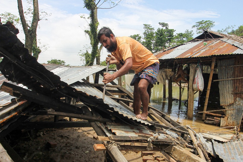 A man fixes his house that was destroyed by a flood in Companiganj, Sylhet, Bangladesh on June 24, 2022.  Climate disasters such as floods can have a severe effect on mental health, such as by causing anxiety and depression. Photo: AFP