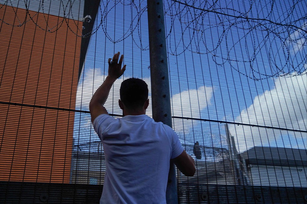 A protester communicates with people inside Brook House Immigration Removal Centre. File photo: AFP