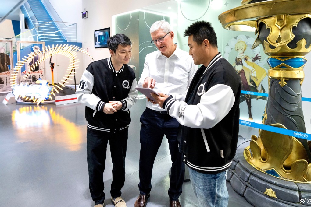 Video gaming developer miHoYo co-founder Liu Wei, left, is seen in a huddle with Apple chief executive Tim Cook, centre, and an unidentified developer of hit game Genshin Impact at the Chinese firm’s headquarters in Shanghai on March 30, 2023. Photo: Weibo