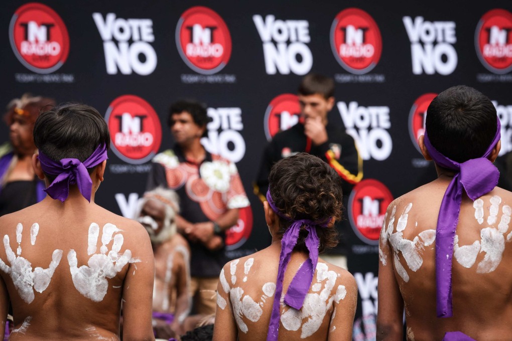 Indigenous performers stand in front of a banner at a rally in Sydney to show their opposition to landmark Indigenous reform. Photo: AFP